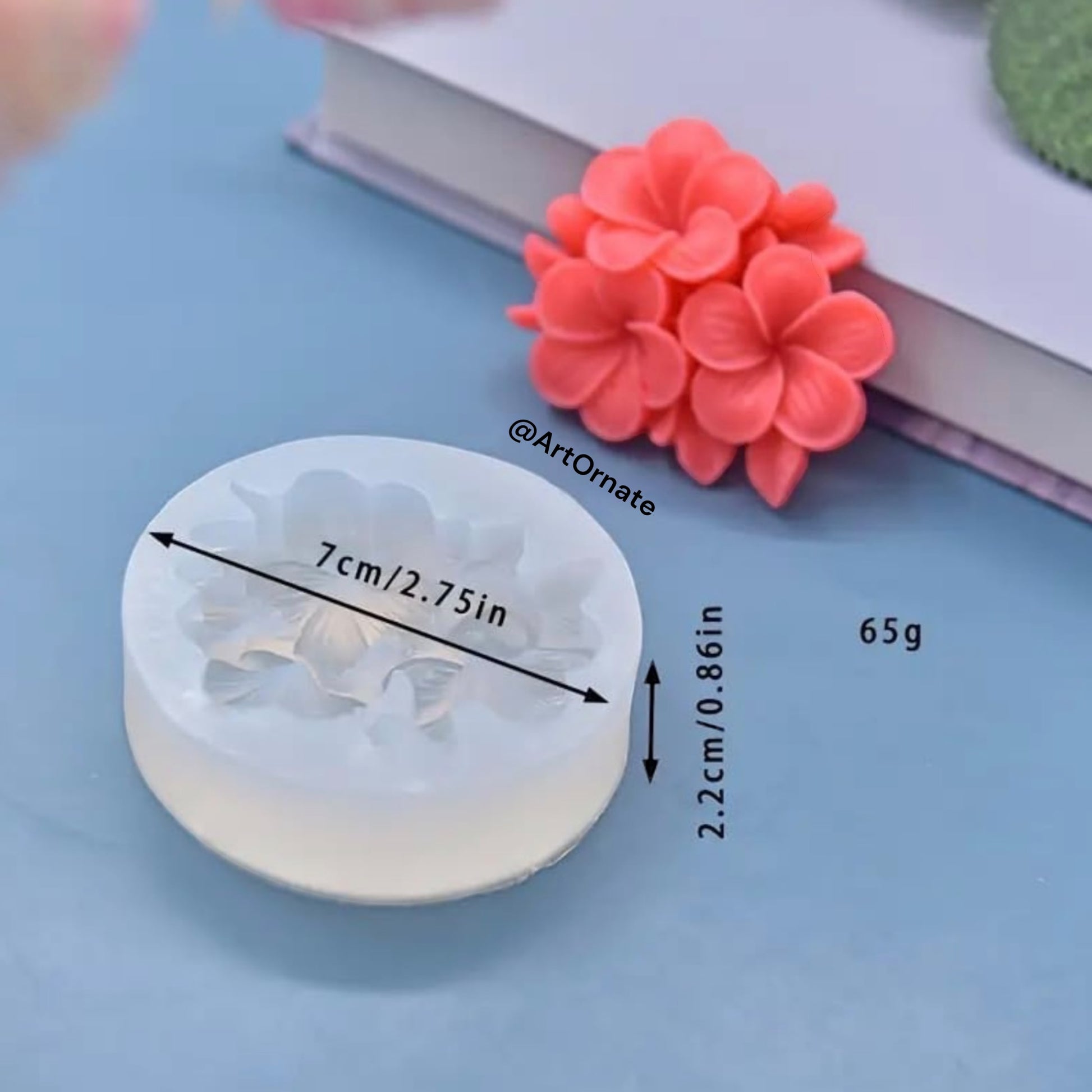 Close-up of a flexible white silicone mould featuring a detailed 3D Plumeria flower design for candle making.